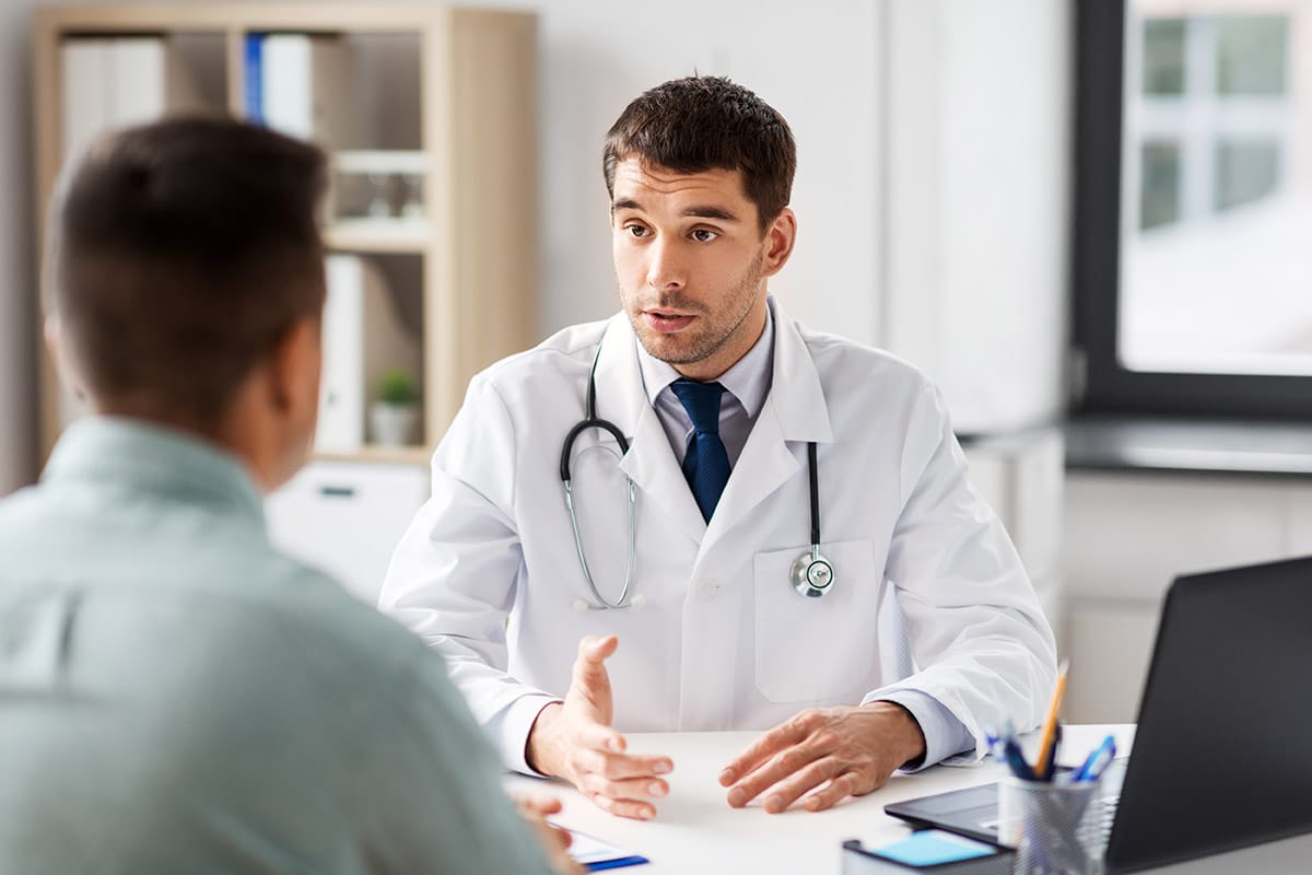 Doctor explains medically supervised treatment to a patient at his desk