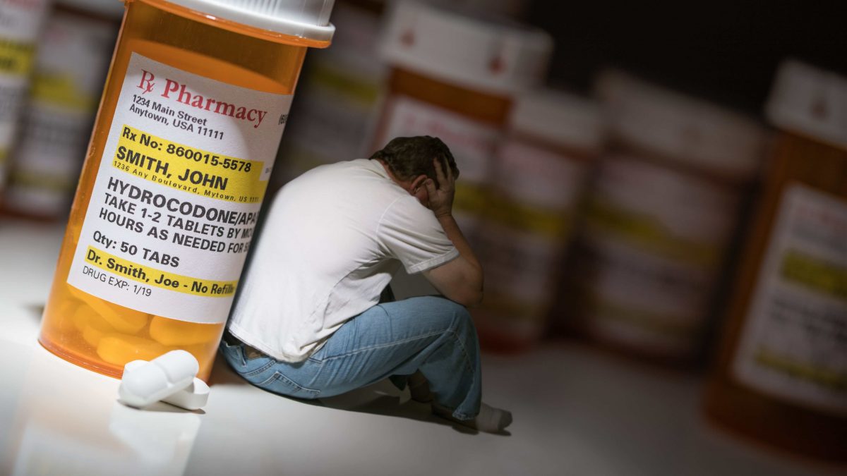addict sitting next opioid depicting addiction