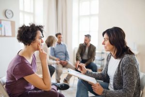 therapist talking to individual during group therapy