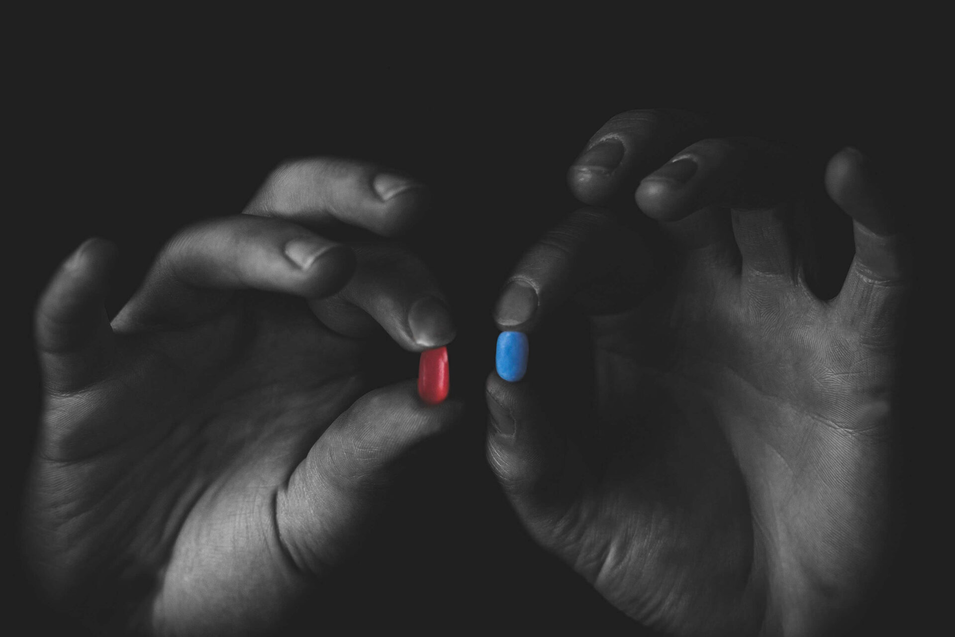 man holding two different prescription pills