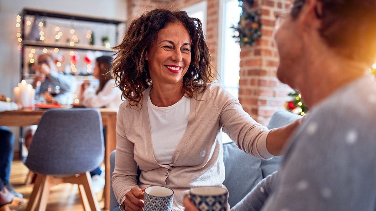 Two friends drinking coffee, enjoying a sober holiday season
