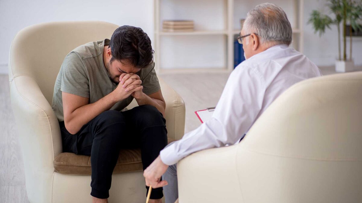 Doctor talks to crying patient in a mens addiction treatment center in Wakefield, MA