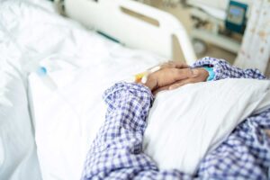 Patient lies in hospital bed in a PHP