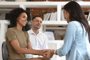 Woman shakes hand with therapist after successful family therapy program