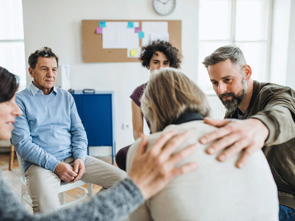 People comfort a person in group therapy while attending an outpatient addiction treatment center in Wakefield, MA